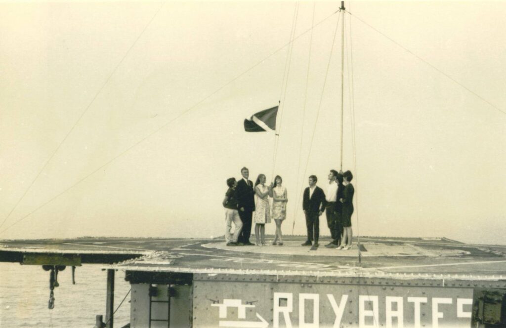 Ο Ρόι Μπέιτς μαζί με τη σύζυγό του Τζόαν και τα παιδιά τους Πενέλοπε και Μάικλ υψώνουν τη σημαία του πριγκιπάτου του Σίλαντ (1967)