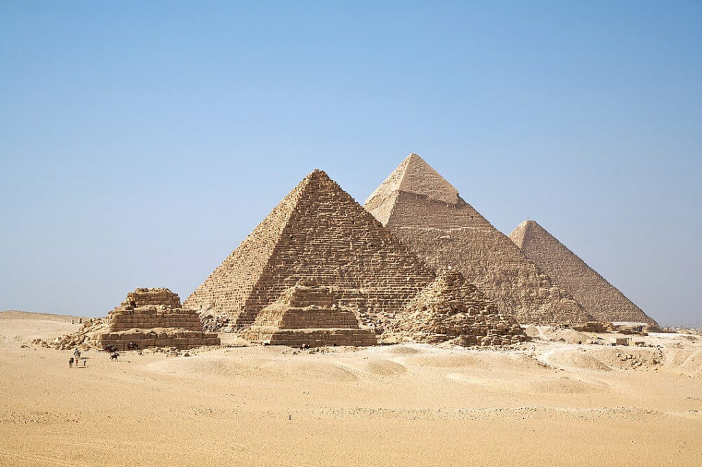 Άποψη των πυραμίδων της Γκίζας από το οροπέδιο προς τα νότια του συγκροτήματος. Από αριστερά στα δεξιά, η Πυραμίδα του Μυκερίνου, Χεφρήνου, και Χέοπα. Οι τρεις μικρές πυραμίδες ανήκουν στις βασίλισσες. (πηγή: wikipedia)