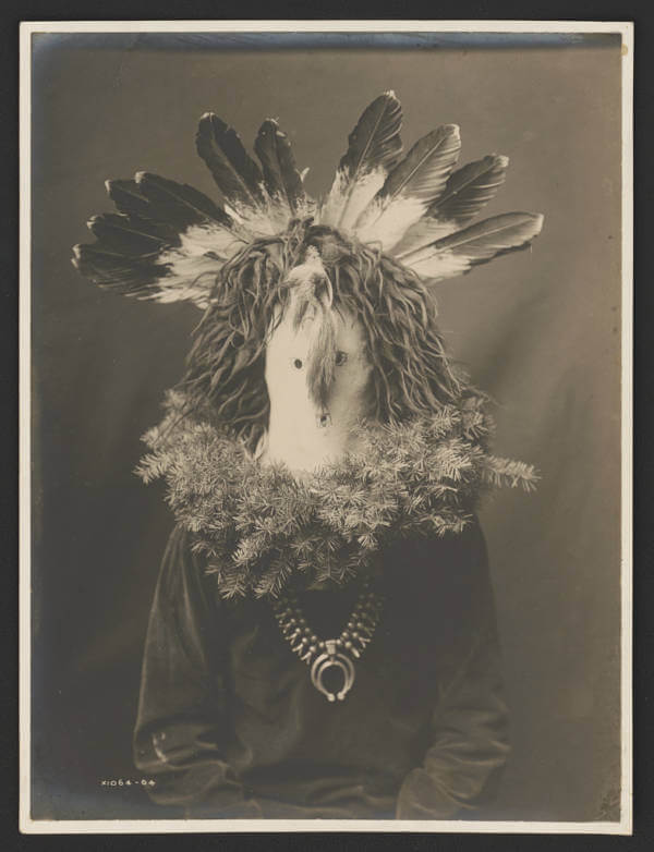 Άνδρας Ναβάχο φοράει μια τελετουργική μάσκα με φτερά και με κλαδιά έλατου που σχηματίζουν ένα στεφάνι γύρω από τους ώμους, 1904. (πηγή: Edward Curtis/Library of Congress)